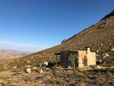 an abandoned building on the side of a hill