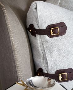 two pieces of luggage sitting on top of a white table next to a pillow and bowl