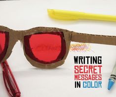 a pair of red glasses sitting on top of a table next to a marker and pen