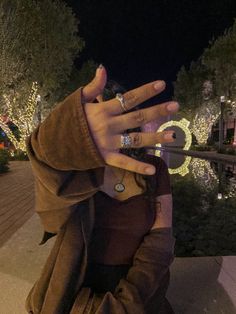 a woman with her hand on the top of her head in front of christmas lights