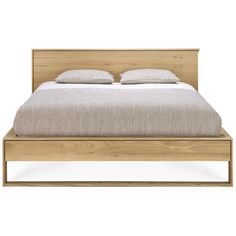 a bed with two pillows on top of it and a headboard made out of wood