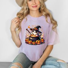 Get into the spooky spirit with this adorable and  Halloween cat making a witches brew! This shirt is perfect for Halloween lovers of all ages. Whether you're attending a costume party, handing out candy, or just feeling festive, this charming design is sure to make you the center of attention. Embrace the magic of the season with this whimsical and cozy shirt--purrfect for Halloween night! Comfort Colors introduces the "Comfort Colors 1717" garment-dyed t-shirt The soft-washed, garment-dyed fabric brings extra coziness to your wardrobe while the relaxed fit makes it an excellent daily choice. The double-needle stitching throughout the tee makes it highly durable while the lack of side-seams helps the shirt retain its tubular shape. Spooky Halloween Cat Design Top, Halloween Lovers, Witches Brew, Cat Shirt, Halloween Night, Halloween Women, Cat Shirts, Halloween Cat, Dyed Fabric