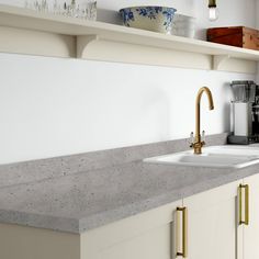 a kitchen counter top with a sink and coffee maker in the backgrouund