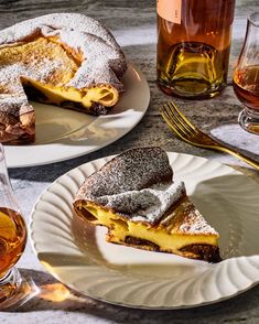 there are two plates with desserts on them next to some glasses and wine bottles