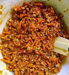 the food is being mixed together in a large bowl with a butter stick on top