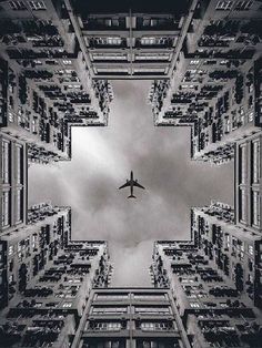 an airplane is flying through the sky over some buildings