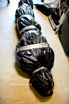 several black bags are lined up on the floor