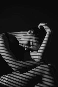 a woman sitting in a chair with her hands on her head and arms behind her head