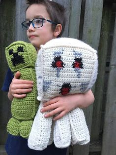 a young boy holding a crocheted stuffed animal