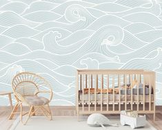 a baby's room with a crib, rocking chair and wallpaper that looks like waves