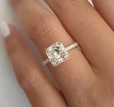 a woman's hand with an engagement ring on it and a diamond in the middle