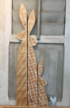 a wooden bunny decoration sitting on top of a shelf next to a blue bird figurine