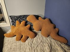 two stuffed animals laying on top of a bed