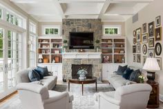 a living room filled with furniture and a flat screen tv mounted on the wall above a fireplace