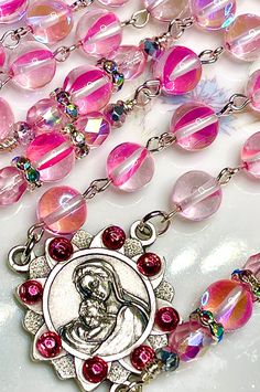 So ethereal, this beautiful fairytale pink rosary is made completely of smooth round mystic aura Quartz gemstones with aurora borealis Preciosa crystals, and they have a gorgeous blue rainbow that reflects in the light. This gemstone has a very nice density, so this rosary is perfect if you like your rosary to have some weight to it. All of the prayers are said on the 8mm faceted gemstones, and the Pater prayers are flanked with embellishments and pink Preciosa crystal beads. I have crystallized Pink 8mm Beads Jewelry For Wedding, Pink Spiritual Jewelry For First Communion, Pink Rosary, Catholic Communion, Mystic Quartz, Quartz Gemstones, Bouquet Bridal, Catholic Wedding, Blue Rainbow