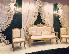 an elaborately decorated stage with white and gold furniture