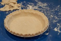 an uncooked pie crust sitting on top of a blue counter