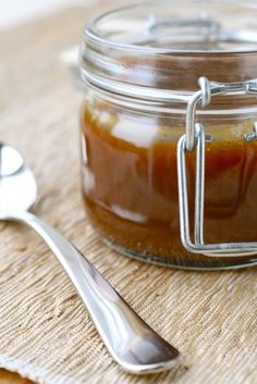 there is a jar with some food in it and a spoon on the table next to it