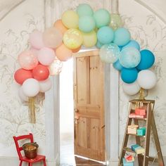 an arch made out of balloons in front of a door