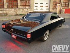 an old black car parked in front of a building