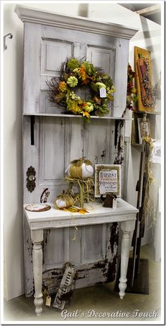 an old cabinet is decorated with wreaths and other decorations for fall or thanksgiving time