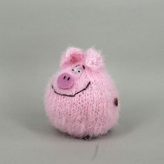 a pink stuffed pig sitting on top of a white table next to a gray wall