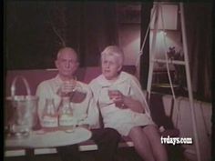 an old black and white photo of two people sitting at a table with drinks in front of them