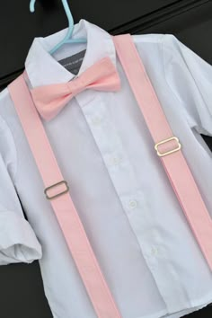 a white shirt with pink suspenders and a bow tie