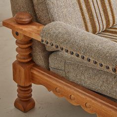 a close up of a couch with buttons on the armrests and wooden posts