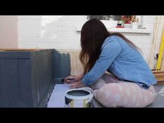 a woman is painting the walls in her house with blue and white paint on it