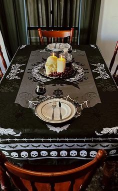 a dining room table with two candles on it and plates in front of the table