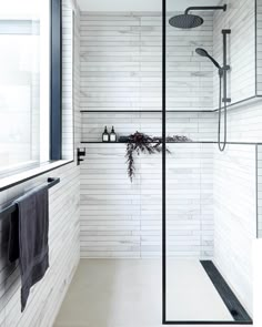 a white tiled bathroom with black accents