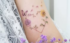 a woman's arm with purple flowers and butterflies on it, next to a lace doily