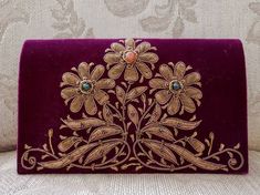 "Spectacular hand embroidered velvet clutch, using copper colored metallic threads, and semi precious stones, in the zardozi tradition. Genuine semi-precious stones sewn into the center of each flower. On lush, rich velvet in maroon color - a deep crimson red with brown and purple undertones. Own a piece of art from the historic city of Agra, home of the Taj Mahal. Zardozi is from the Persian and means \"gold thread\" . It is an elaborate art of multidimensional embroidery using gold and silver Traditional Clutch With Gold Embroidery As Gift, Traditional Gold Embroidery Clutch As Gift, Traditional Velvet Bags As Gifts, Traditional Velvet Bags For Gifts, Handmade Velvet Clutch As Gift, Handmade Velvet Clutch As A Gift, Traditional Velvet Clutch For Formal Occasions, Handmade Rectangular Velvet Clutch, Traditional Embroidered Velvet Clutch