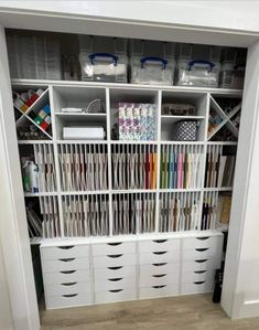 an organized closet with white drawers and bins filled with crafting supplies on shelves