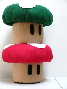 two mushroom pillows stacked on top of each other in front of a white wall and floor