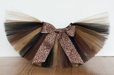 an animal print and leopard print tulle bow on top of a wooden table with a white wall in the background