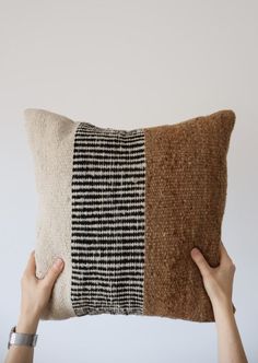 a person holding up a pillow with two different colors