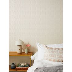 a bedroom with a bed, nightstand and wallpaper