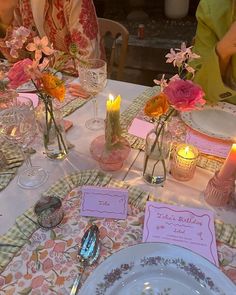 the table is set with flowers and candles