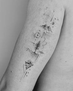 a black and white photo of a man's arm with an abstract tattoo on it