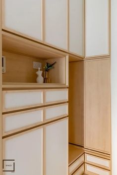 an empty room with white cabinets and wood trimmings on the walls, along with a potted plant