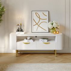 a white and gold console table with flowers on top