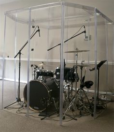 a group of musical instruments sitting inside of a glass structure in the middle of a room