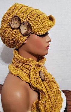 a mannequin head wearing a knitted hat and scarf with buttons on it