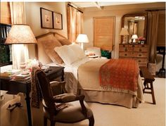 a bed room with a neatly made bed next to a desk and chair in front of a window