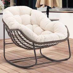 a white chair sitting on top of a wooden floor next to an umbrella and window