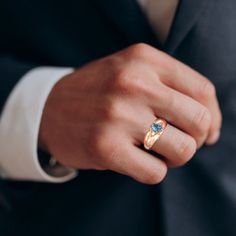 a man in a suit and tie wearing a ring with an amethorate stone