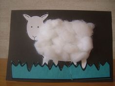 a sheep made out of paper sitting on top of a wooden table