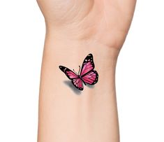 a small pink butterfly tattoo on the left wrist and right hand, with black outline